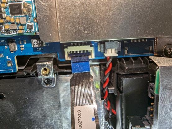 The same view of the same laptop with the ribbon cable in place, but with nothing to retain it.