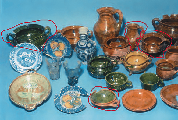 A large group of archeological pottery and glass with many colors and different shapes. Some pieces are broken of glued together.