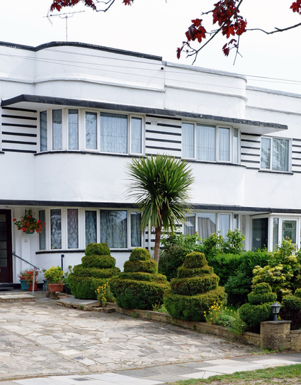 A colour photograph of a pair of semi detached houses on Abbotshall Avenue with decorative stripes and flat roofs