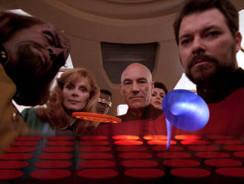 Worf, Beverly, Geordi, Troi, Picard and Riker looking at the game screen with blank stares