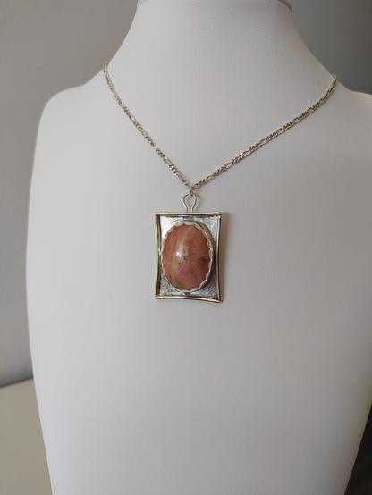 a pendant, it has an oval stone in silver rectangular frame. It has also a silver chain