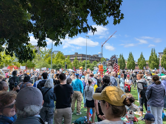 a large crowd of mostly young people listens to speakers during a rally at the beginning of the No Kings demonstration at Cal Anderson Park in Seattle