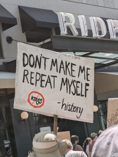 a sign somebody carries during the No Kings march says, "don't make me repeat myself - [signed] history