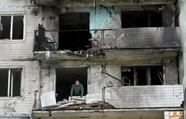 A local resident of a damaged residential building looks on as he clears debris following a Russian strike in Kyiv in May 2025, amid the Russian invasion in Ukraine