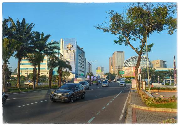 A three lane street with cars in a city.