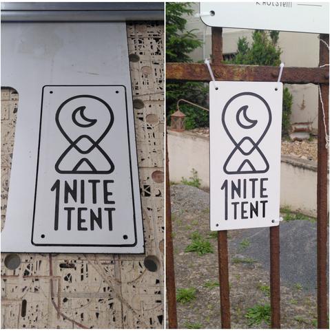 Das Bild ist zweigeteilt und zeigt zwei Aufnahmen desselben Schildes an unterschiedlichen Orten. Auf dem Schild ist das Logo von "1 Nite Tent" sehen. Das Design ist in Schwarz-Weiß gehalten.

Linkes Bild: Das Schild liegt noch auf der CNC-Fräse und wurde gerade frisch ausgefräst.
Rechtes Bild: Das Schild ist mit Kabelbindern an einem rostigen Metallzaun befestigt. Im Hintergrund ist ein Hof mit Kies, Pflanzen und einem kleinen Windlicht zu sehen.