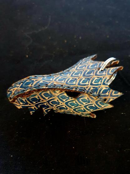Blue leather dragon keychain on a black background