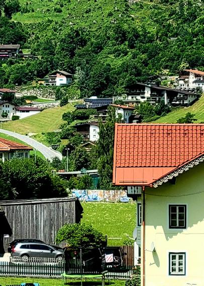 Picture of homes and other buildings on a green mountain slope.