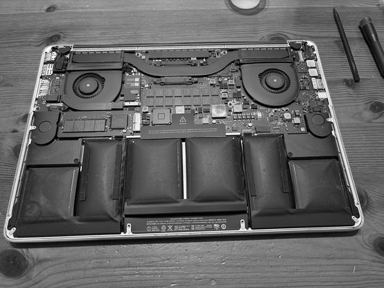 Back of open laptop showing swollen batteries