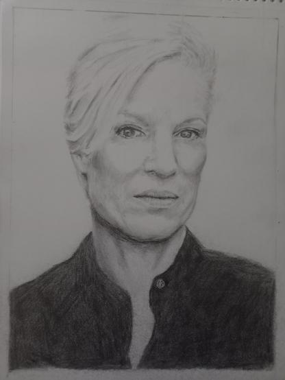 Graphite drawing, a portrait of a woman with short blonde hair and dark eyes, wearing a dark buttoned blouse.