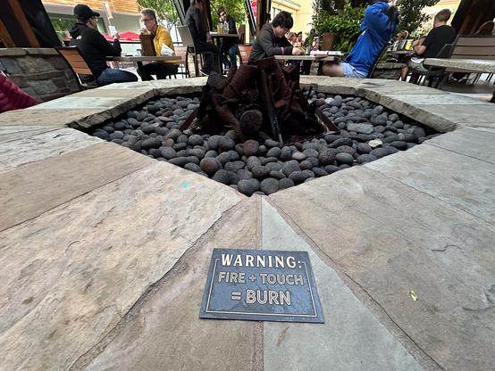 A sign at a fire pit: Warning: Fire + Touch = Burn