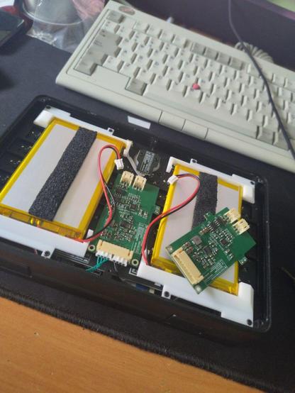 Charging board replacement process on an MNT Pocket Reform, with the case open and tools around the device.
