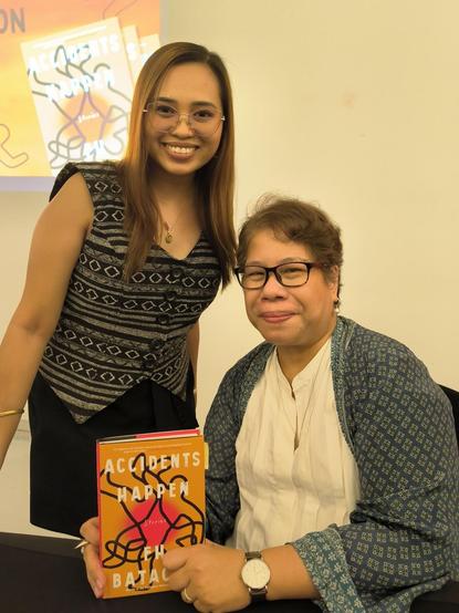 woman in filipiniana vest posing with the author fh batacan holding a signed copy of her latest book