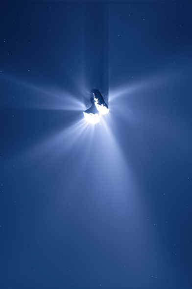 An image of Comet 67P/Churyumov-Gerasimenko seen from the ESA Rosetta spacecraft in 2015. The comet's coma is spread in all directions around the comet, and the comet is casting a shadow on the coma towards the top of the image, with the sunlight coming from below. The image is originally monochrome and has been colourised with a blue palette.