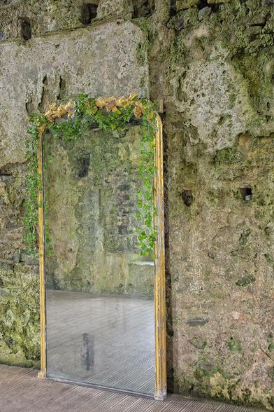 Mirror standing against a medieval Norman wall inside Manorbier castle in Wales