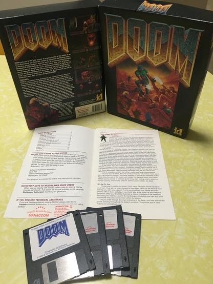 The original 1993 PC game Doom, featuring the game's box, manual, and several 3.5-inch floppy disks.