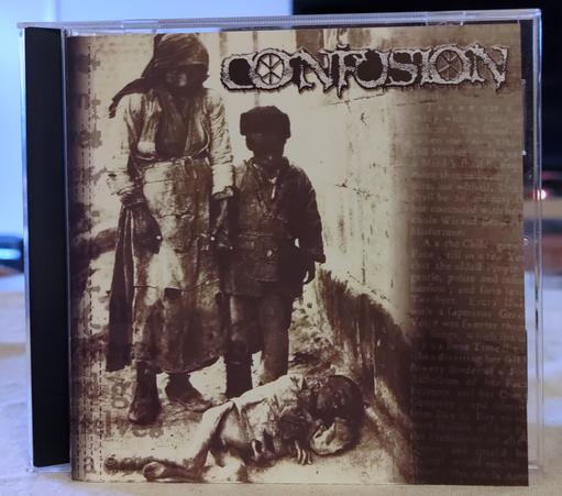 CD cover with a sepia-colored, very bleak, image of a woman and boy in worn-out clothes looking at a starving boy laying on the street. 

Confusion logo, top right.