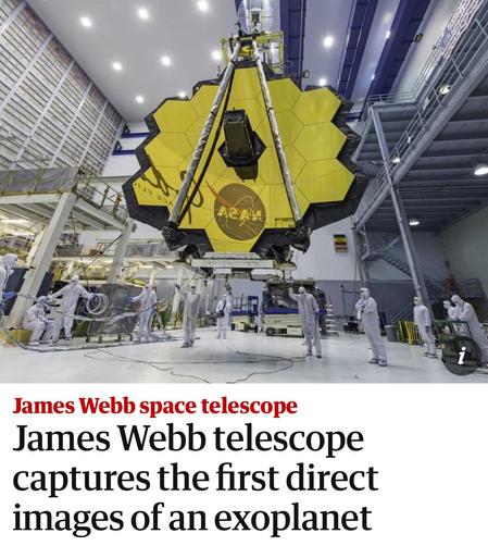 The image depicts the James Webb Space Telescope in a large indoor facility, with its distinctive golden, hexagonal segmented mirror visible. Several technicians in white protective suits are working around it, indicating ongoing testing. The newspaper headline below highlights that this telescope has captured the “first direct images of an exoplanet”.