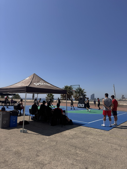 Basketball players in front, W hotel in backdrop and Barceloneta beach