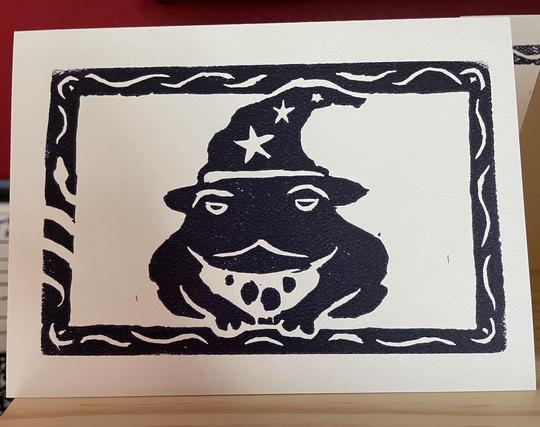 A toad wearing a wizard hat printed in dark purple ink