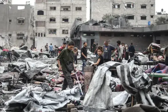 People collect their belongings from the rubble at Yafa School after the Israeli attack [Khames Alrefi/Anadolu]