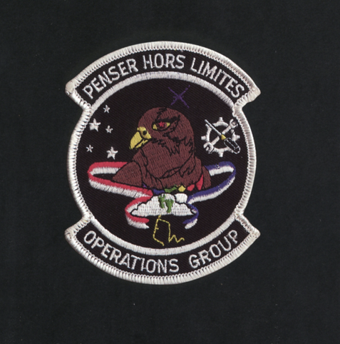 Penser hors limites operations group badge with an eagle with red eyes and stars around it