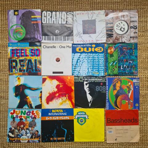 Sixteen seven-inch singles laid out on the floor. Colourful sleeves. Text which stands out is "grand piano", "feel so real" and "jungle brothers"
