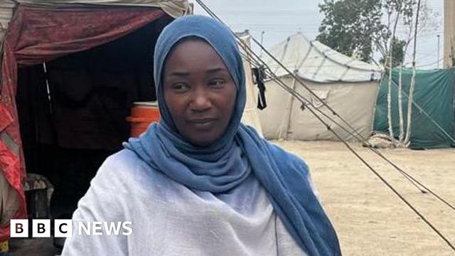 Woman in a blue headscarf looks to her right.