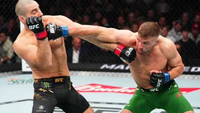 TORONTO, ONTARIO - JANUARY 20: (R-L) Dricus Du Plessis of South Africa punches Sean Strickland in a UFC middleweight championship bout during the UFC 297 event at Scotiabank Arena on January 20, 2024 in Toronto, Ontario. (Photo by Jeff Bottari/Zuffa LLC via Getty Images)