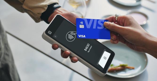A lifestyle image showing the Square Handheld accepting a contactless card payment.