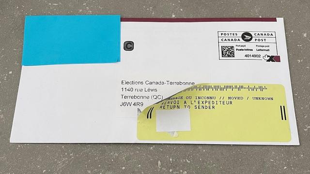 Une enveloppe avec un collant de renvoi à l'expéditeur est posée sur une table.