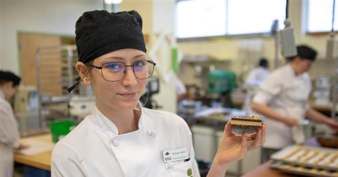 Baking and Pastry Arts Management Diploma Program student Shayla Jane Heslin holds up a Nanaimo bar. (VIU)