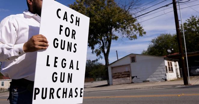 A private gun buyer advertises cash sales outside the Alamodome parking lot where the City of San Antonio hosts a gun buyback event on Nov. 24, 2024.