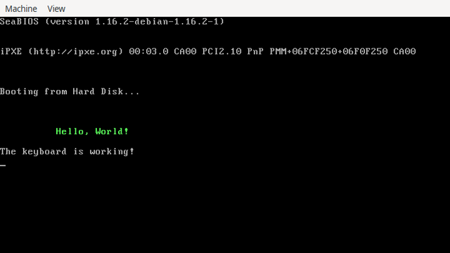 A console is shown displaying a system’s startup information, followed by “Booting from Hard Disk …”, “Hello World!” in a green font, and “The keyboard is working!”