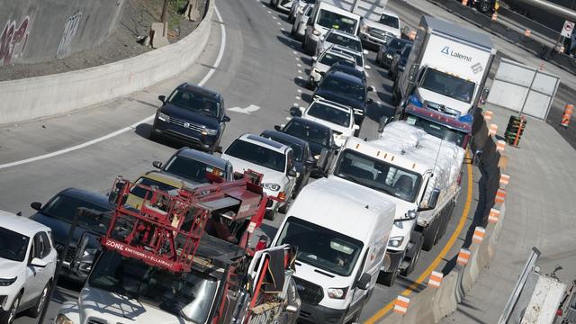 Des véhicules à la queue leu leu sur deux voies d'une autoroute congestionnée longeant un chantier routier. Des véhicules à la queue leu leu sur deux voies d'une autoroute congestionnée longeant un chantier routier.