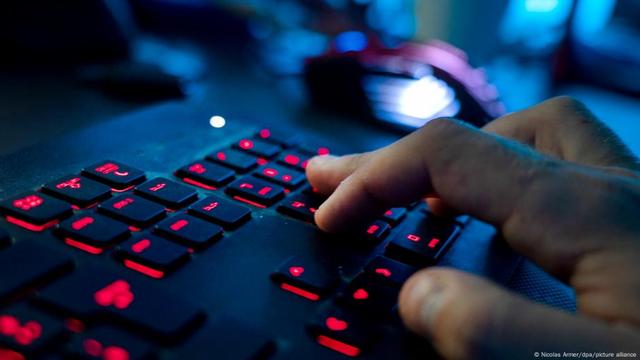 Stock photo: fingers are seen typing on a keyboard illuminated in red. | Image: Nicolas Armer/dpa/picture alliance