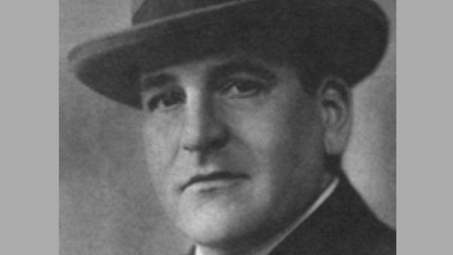 Hugo Bettauer im Anzug und mit Hut. Eine schwarz-weiß Fotografie.