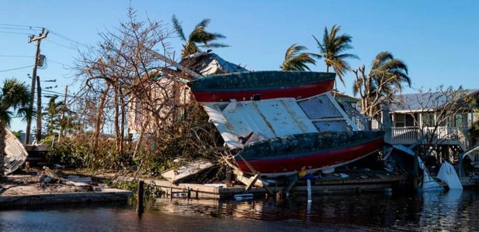 A catamaran on top of a damaged home in Florida after Hurricane Ian.