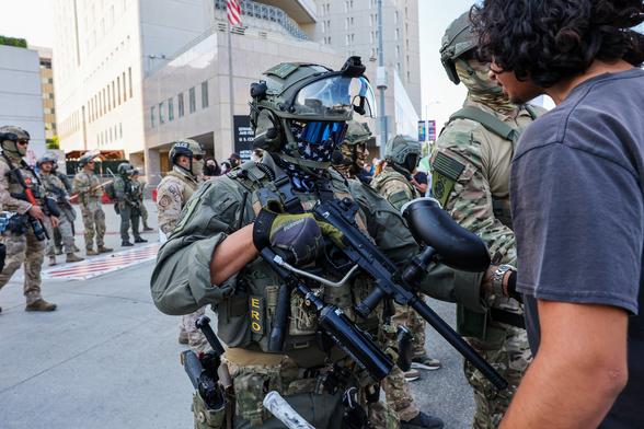 A human being confronts a uniformed and armed agent of the United States