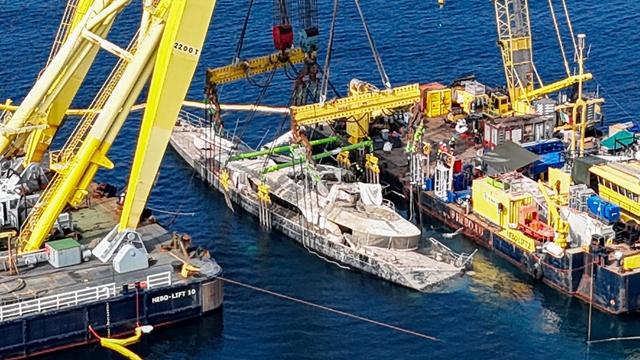 The Bayesian superyacht being lifted by a sea crane.