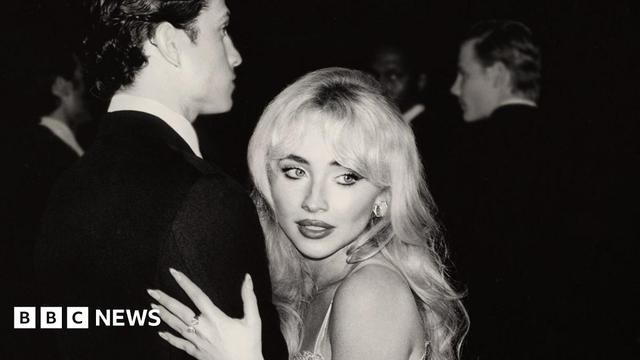 Black and white image of Sabrina Carpenter holding a man's arm