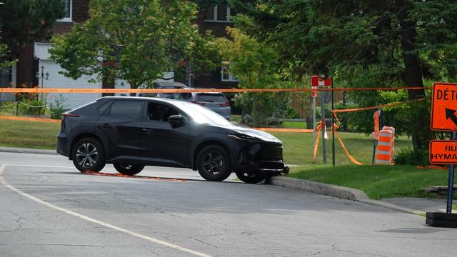Un véhicule accidenté à l'intérieur d'un périmètre de sécurité érigé par des enquêteurs.