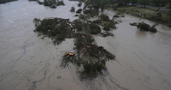 A raging Guadalupe River leaves fallen trees and debris in its wake, Friday, July 4, 2025, in Kerrville, Texas. (AP Photo/Eric Gay)