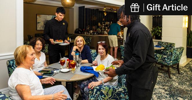 Staff members serving food to residents of Sinai Residences, a retirement community in Boca Raton, Fla. 