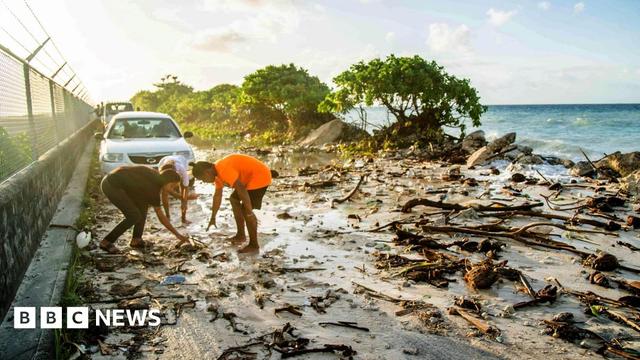 A photo taken in 2021 shows high-tide flooding and debris covering the road to the airport in the Marshall Islands capital Majuro. Storms and tidal surges caused widespread flooding, with rising seas blamed for the inundation in the climate-change affected region. 